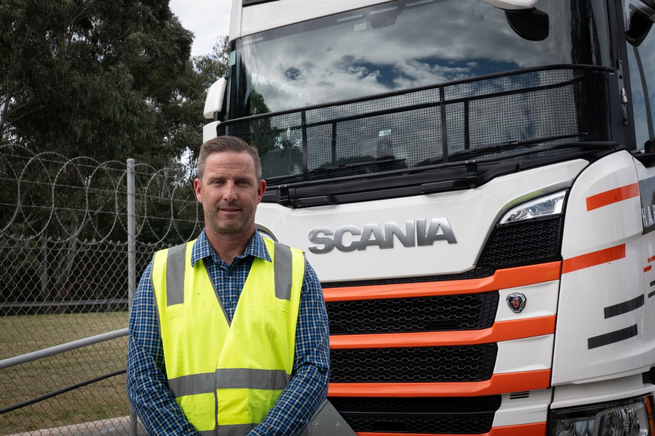 man standing in front of Scania truck