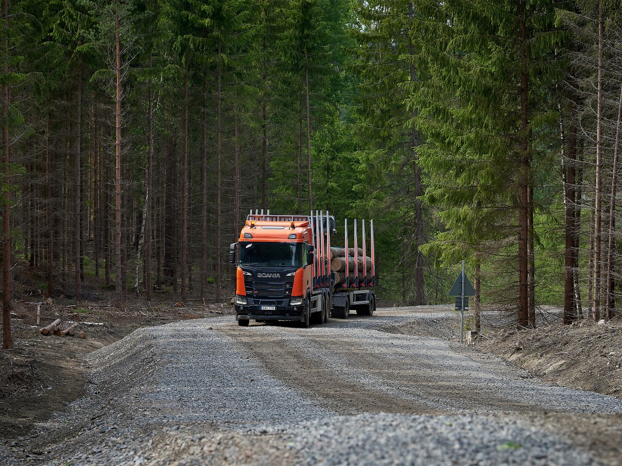En Scania XT timmerbil som kör på skogsväg