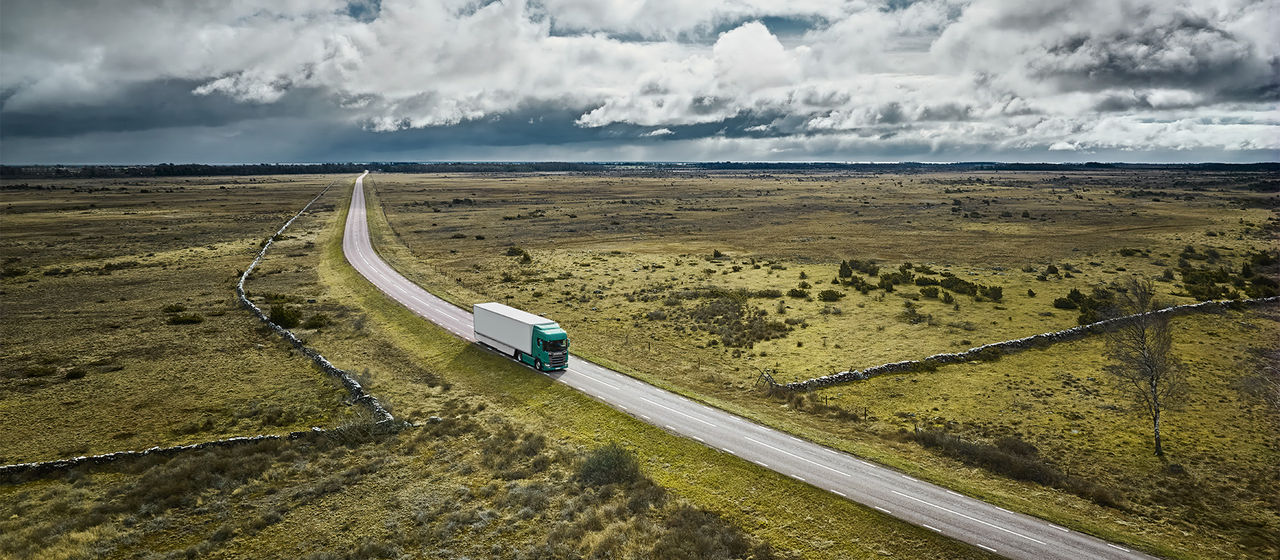 Truck on a road with green fields around